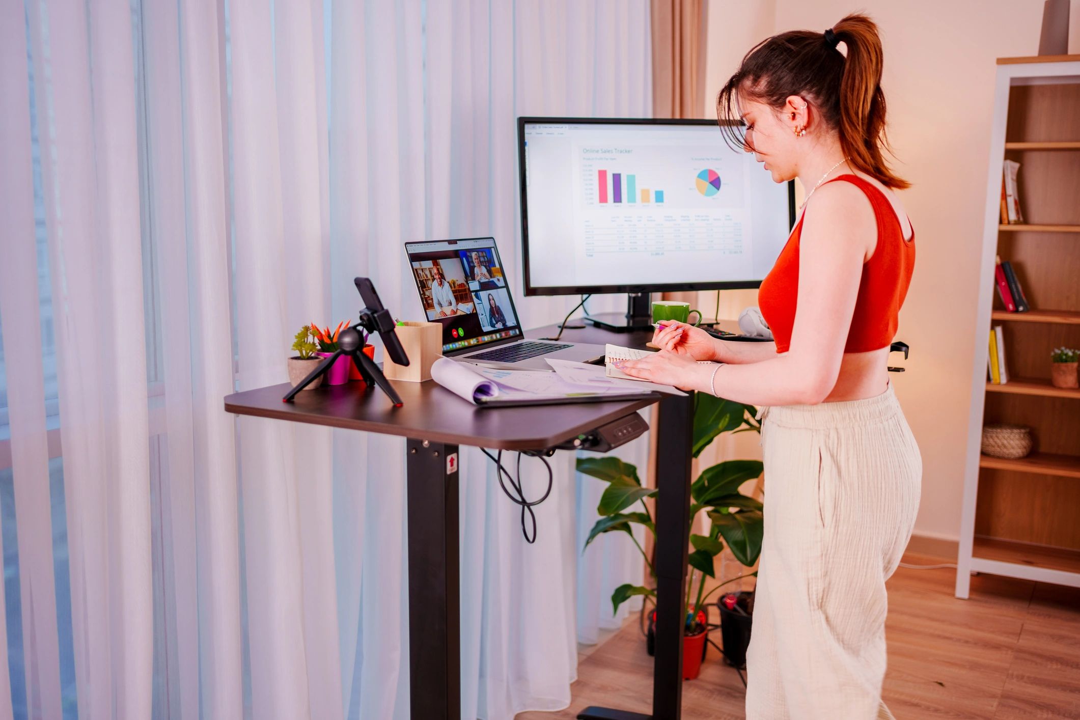 Woman working at a treadmill desk with laptop and monitor